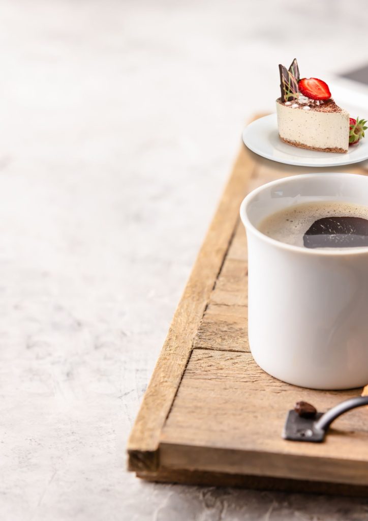 Houten plankje met kopje koffie en taartje bij Femm Assist